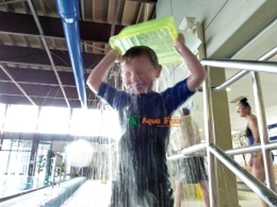 Kind mit Wassereimer beim Schwimmkurs