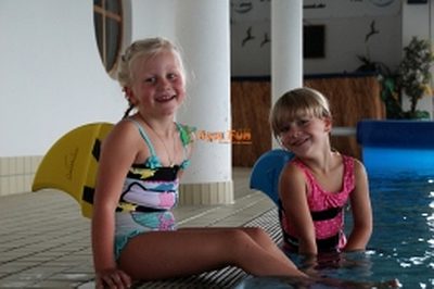 Zwei Mädchen strahlen am Beckenrand